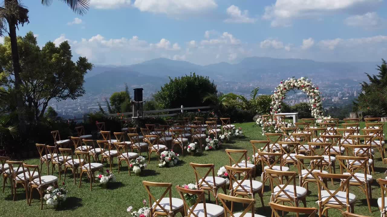 decoración de bodas que tiene lugar al aire libre, con sillas blancas y rosas