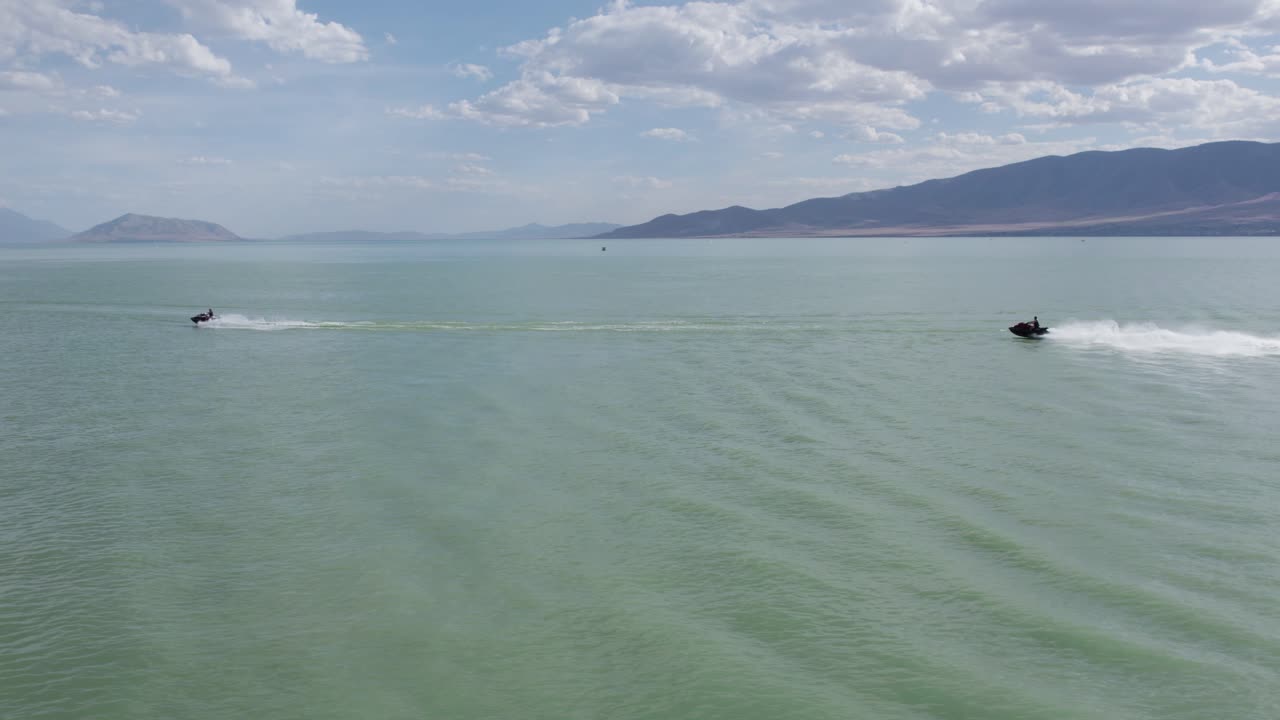 jinetes en jet ski sea doos en el pintoresco y hermoso lago de utah - antena con espacio para copiar en el cielo