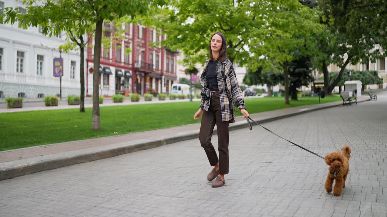 mujer paseando a su perro en un parque de la ciudad