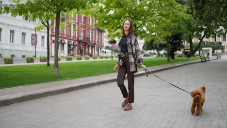 woman walking her dog in a city park