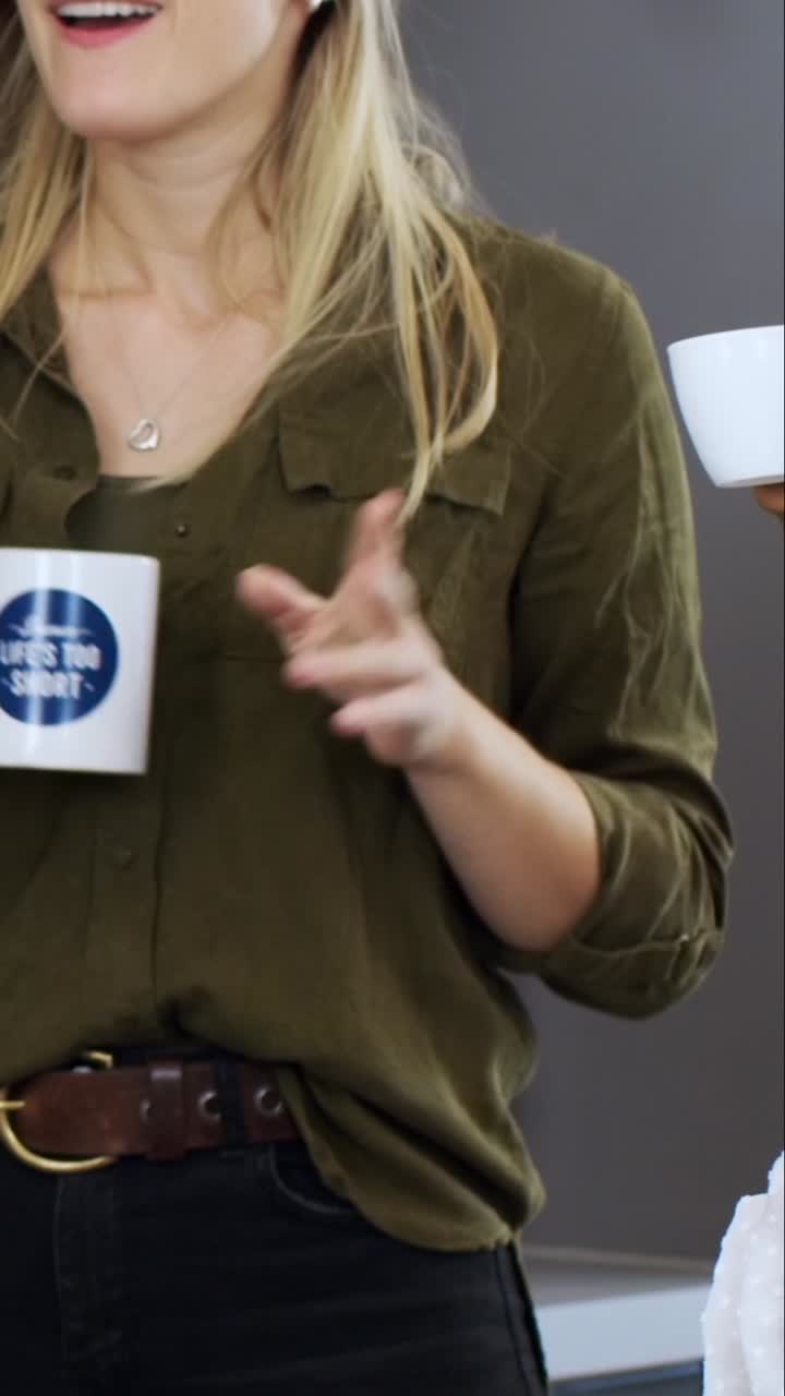 dos jóvenes compañeros de trabajo hablando durante el descanso en la oficina moderna