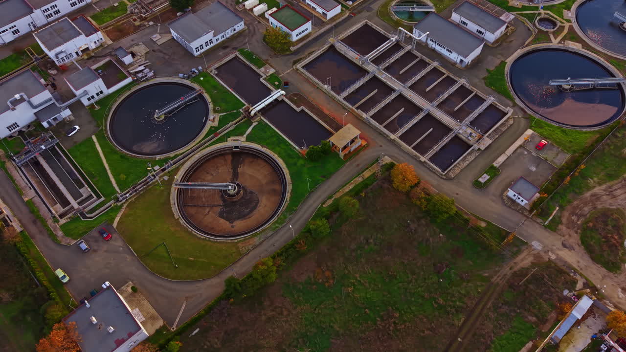 Exploring a modern wastewater treatment facility showcasing advanced technology and green landscapes during the early morning light