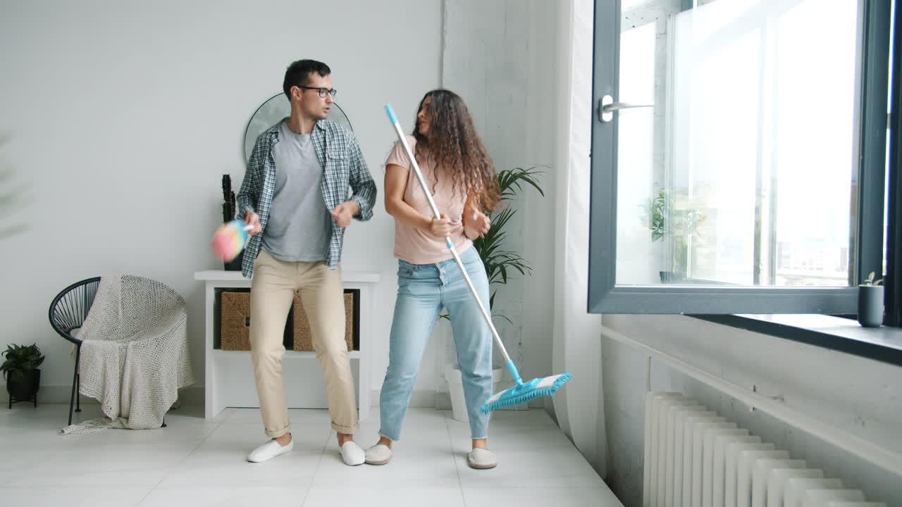 pareja bailando mientras limpia