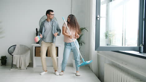 pareja bailando mientras limpia