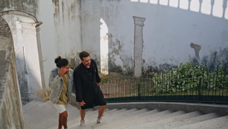 una pareja subiendo escaleras de piedra.