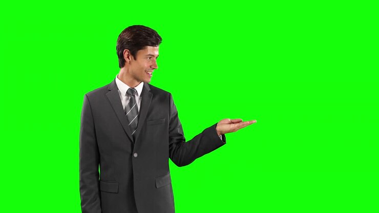 Vista laterale di un uomo caucasico che tiene la mano per uno spazio per il testo con schermo verde