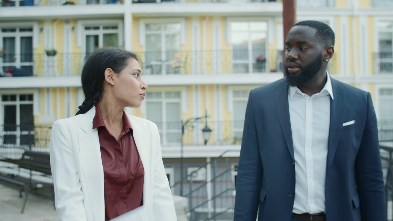 Nervous businessman and businesswoman looking project results at urban street.