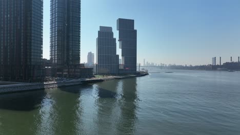 An-aerial-view-of-Newtown-Creek-with-new-high-rise-apartment-buildings-in-Brooklyn,-NY-in-the-background-on-a-sunny-day