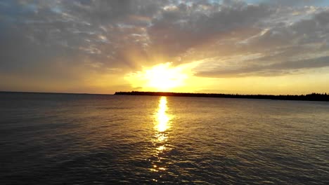 puesta de sol estallando a través de las nubes sobre el océano y las islas