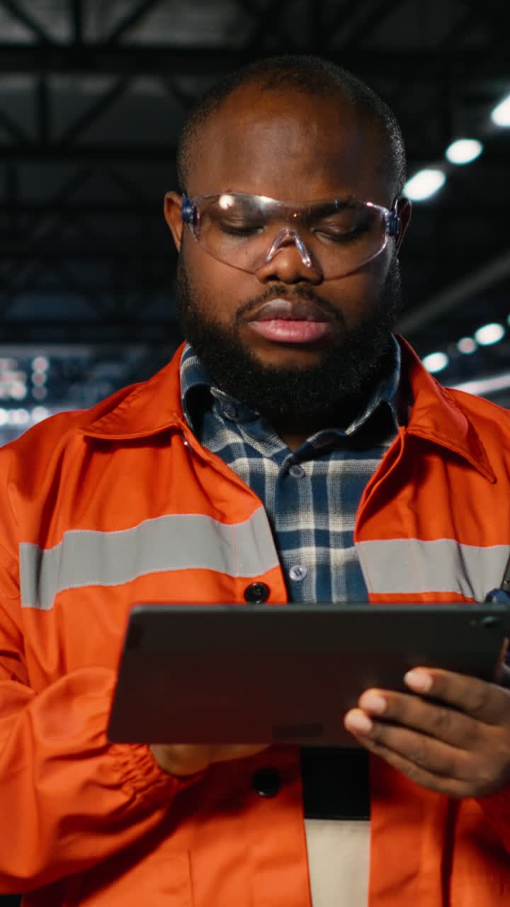 Vertical Video Black professional technician checking workshop equipment in a warehouse