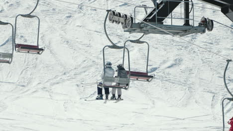 Ski-Lift---Couple-Sitting-On-Chairlift-At-The-Ski-Resort-In-Okuhida-Hirayu,-Gifu,-Japan