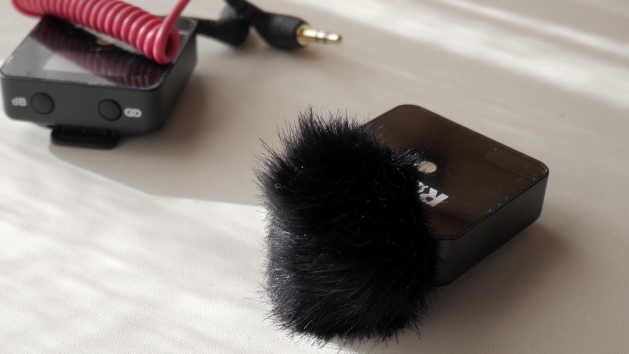 Lavalier mic with furry cover on white table, intimate indoor setting