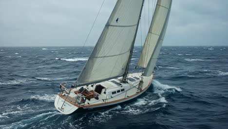a majestic sailing adventure: captivating views of a sailboat navigating through windswept waves under overcast skies