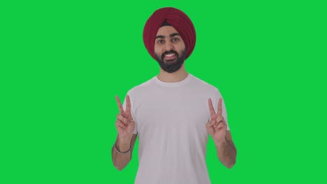 Happy-Sikh-Indian-man-showing-victory-sign-Green-screen