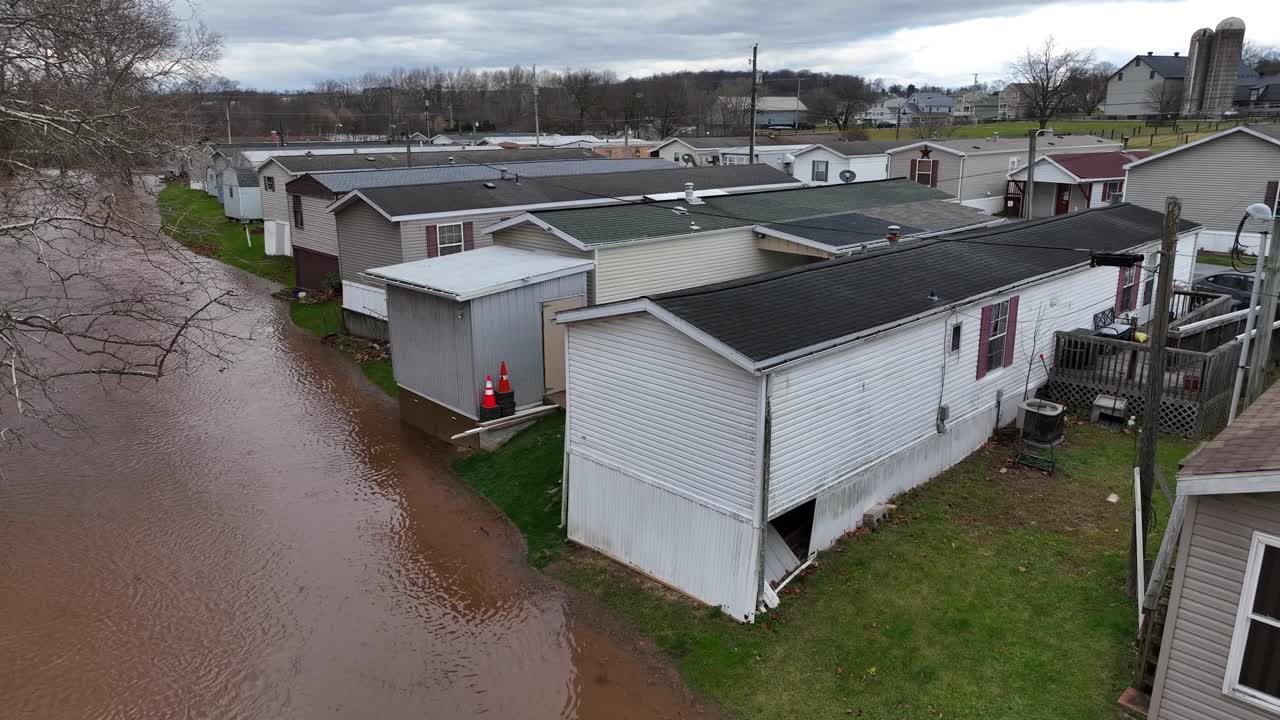 Flooding Mobile home trailer park in USA after heavy rain at night. Environmental catastrophe in american low income district. Aerial rising top down.