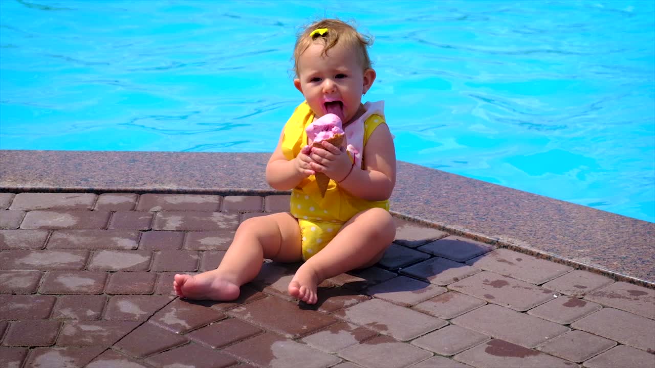 el niño come helado cerca de la piscina. foco selectivo. niño.