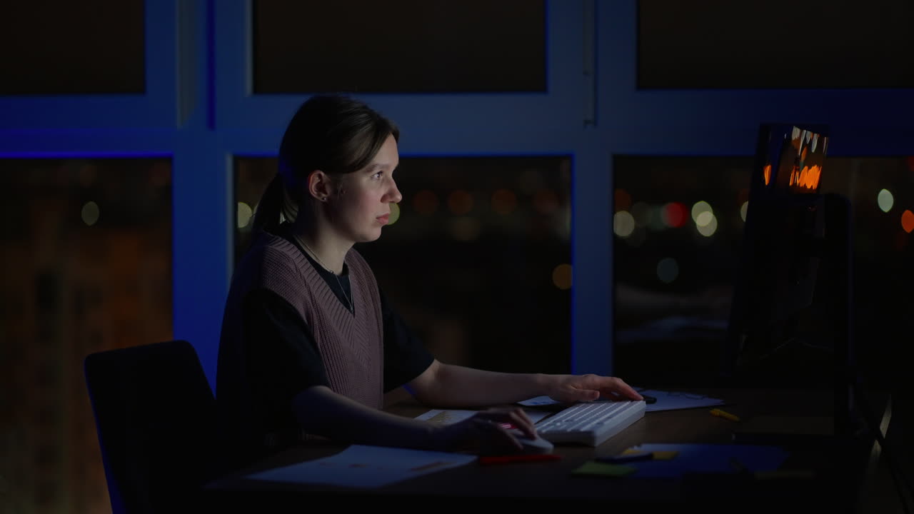 joven caucásica de buen aspecto escribiendo y trabajando en la computadora portátil como freelancer mientras está sentada en casa en la acogedora sala de estar oscura con un gato. por la noche. quedarse en casa