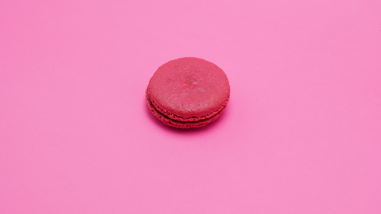 A pink macaroon on a pink background