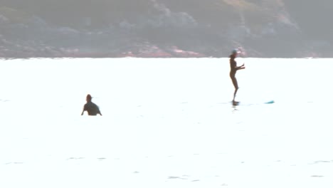 un surfista y un remero en el océano en tofino, columbia británica