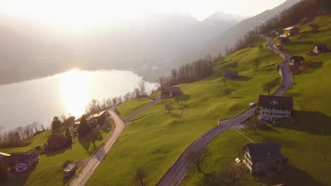 Algunos-Autos-Conducen-Por-Una-Carretera-En-Amden,-Suiza,-Mientras-Se-Pone-El-Sol