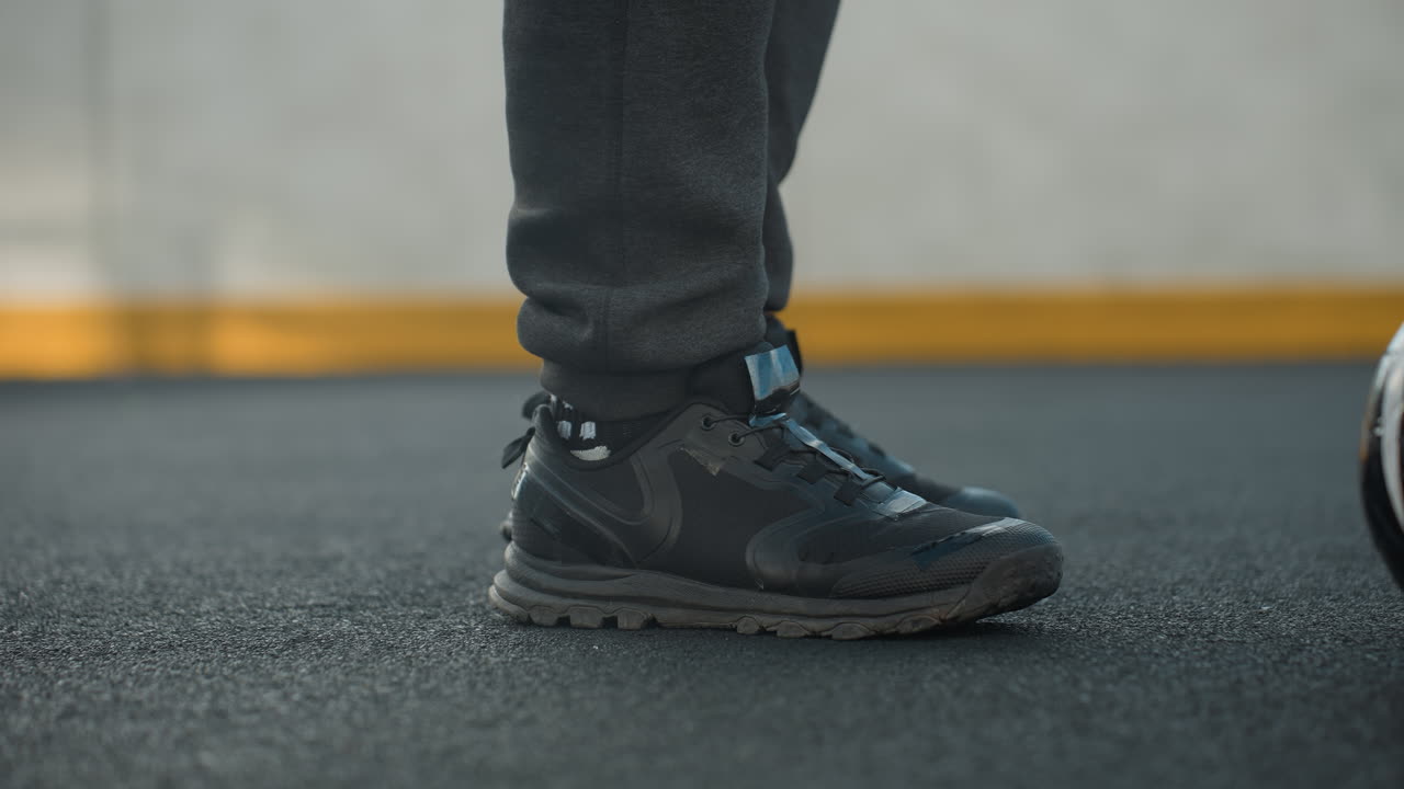 왼쪽 다리와 오른쪽 다리로 정확한 발목 회전을 보여주는 스포츠 여성의 가까운  다리 시각, 사람 앞에 축구 공, 노란색 페인트로 벽