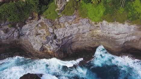 Olas-Rompiendo-En-La-Cueva-De-Escupir-Honolulu-Oahu-Hawaii-Agua-Azul-Brillante-Y-Casas-Elegantes-En-El-Borde-Del-Acantilado---Elevación-Aérea