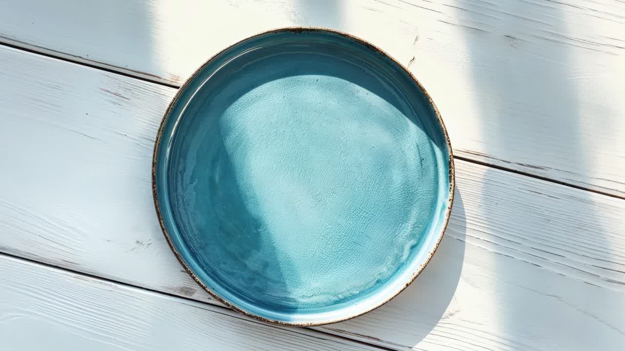 un plato azul vacío en una mesa de madera