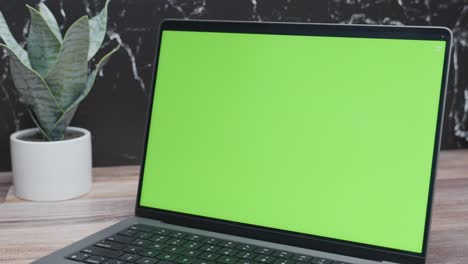 primer plano de una computadora portátil de pantalla verde para una maqueta de sitio web sobre un fondo de mármol negro