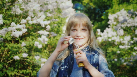 A-Carefree-Girl-Blows-Bubbles-Against-The-Backdrop-Of-Lilac-Bushes-4K-Video