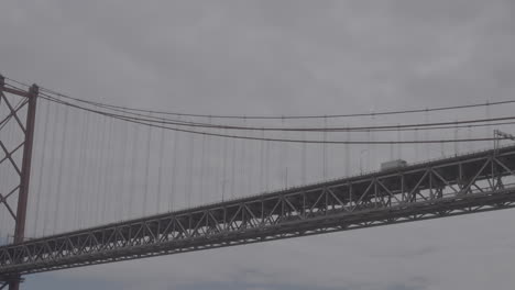 Ponte-De-25-April-In-Lissabon-Portugal-Mit-Einem-Zug-In-Zeitlupe-Und-über-Dem-Wasser