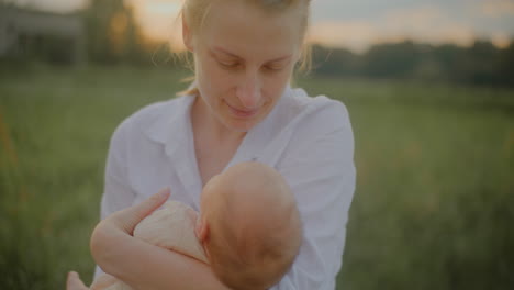 happy mother kissing baby at sunset