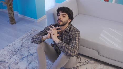 Depressed-and-unhappy-young-man-at-home-alone-in-deep-thought.