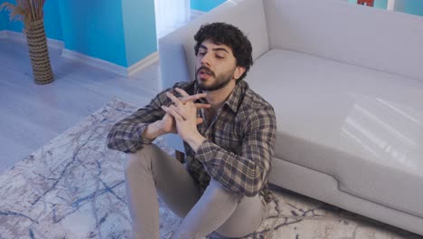 depressed and unhappy young man at home alone in deep thought.