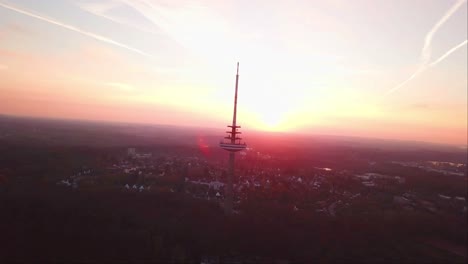 aerial drone shot of kiel transmission tv tower with a reddish evening sky