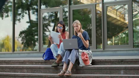 dos estudiantes mujeres estudiando juntas al aire libre