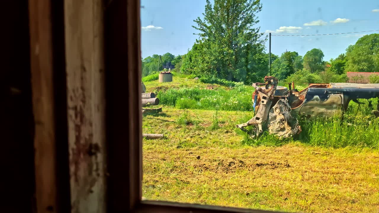 Person driving motorized walk-behind tractor (motoblock) with trailer in rural countryside