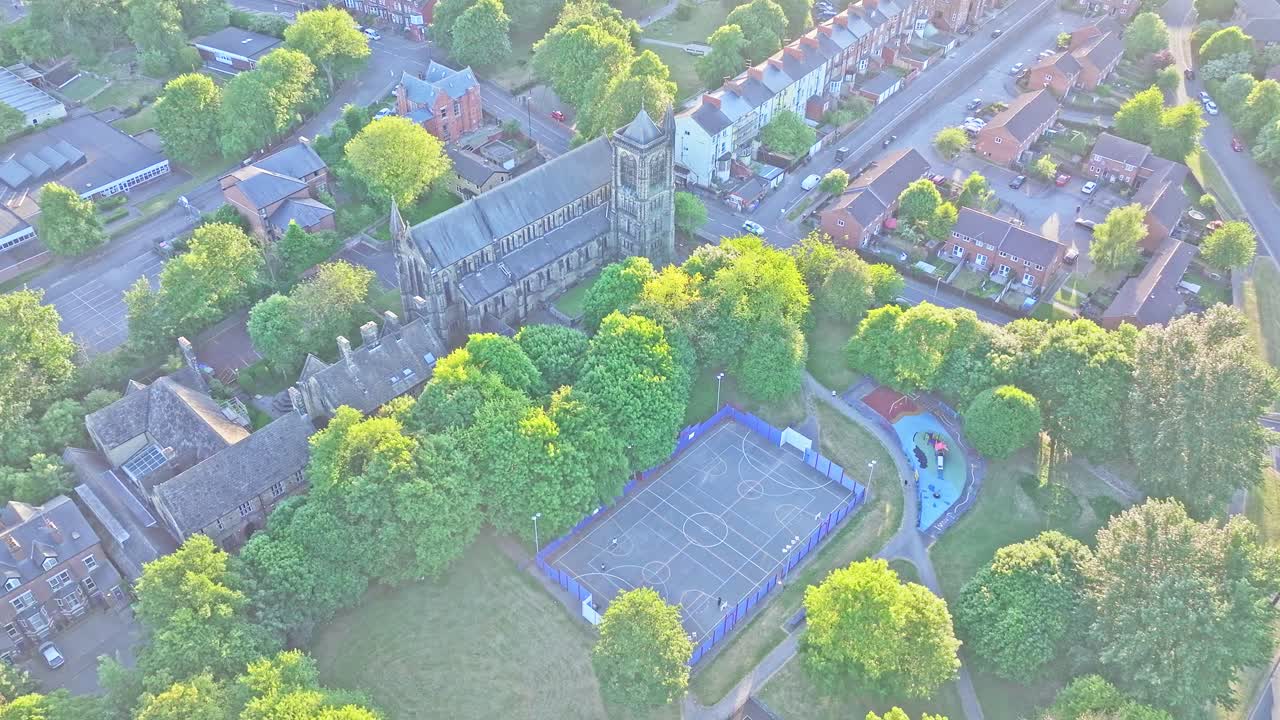 Moor Allerton, a suburban district in Leeds, West Yorkshire, England, centers on St. John the Evangelist Church, a Gothic-style Anglican stone parish with tall tower adjacent to a fenced sports court