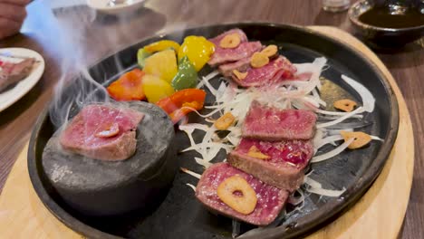 beef cooking on a hot stone with vegetables