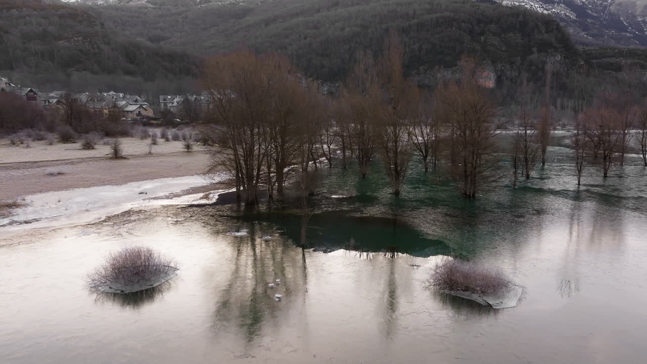 замороженное озеро с деревьями и деревней на заднем плане