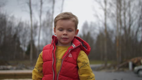 young beautiful boy enjoy time with toy gun outside, close up portrait view