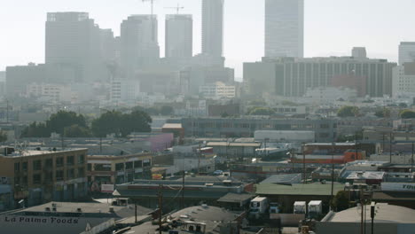 hazy urban city skyline with buildings and construction cranes