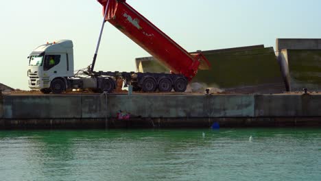 camión descargando rocas , construcción del puerto deportivo de blanes , tormenta gloria
