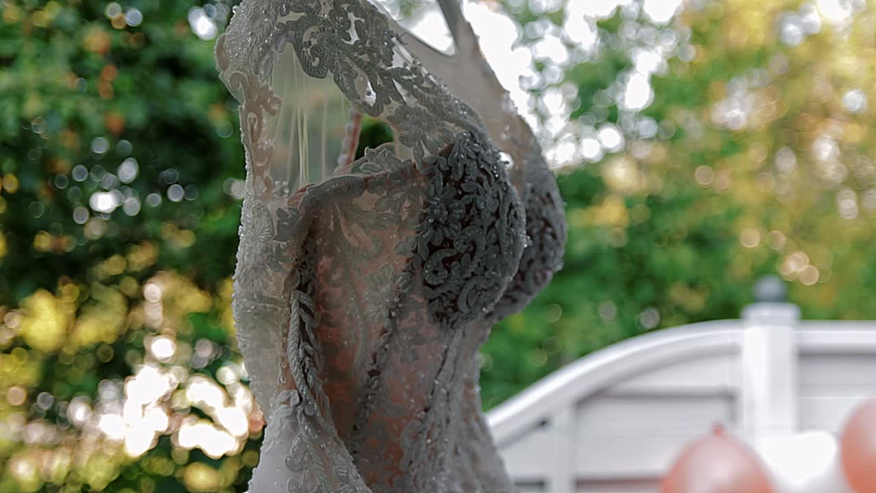 결혼식을 위해 옷을 입을 순간을 기다리는 웨딩 드레스가 매달려 있습니다.