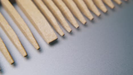 motion past handmade wooden comb on light grey background