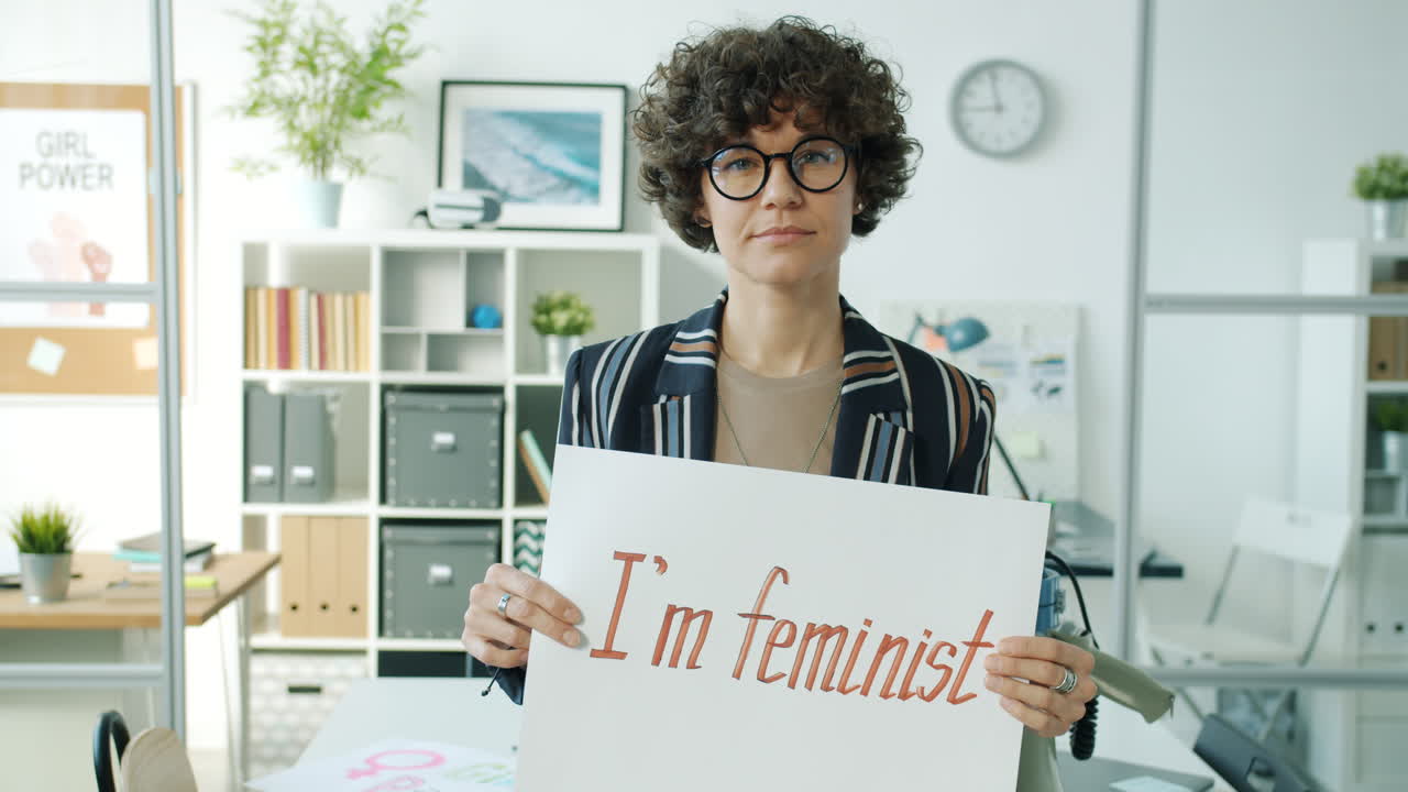 Woman Holding Feminist Poster in Office