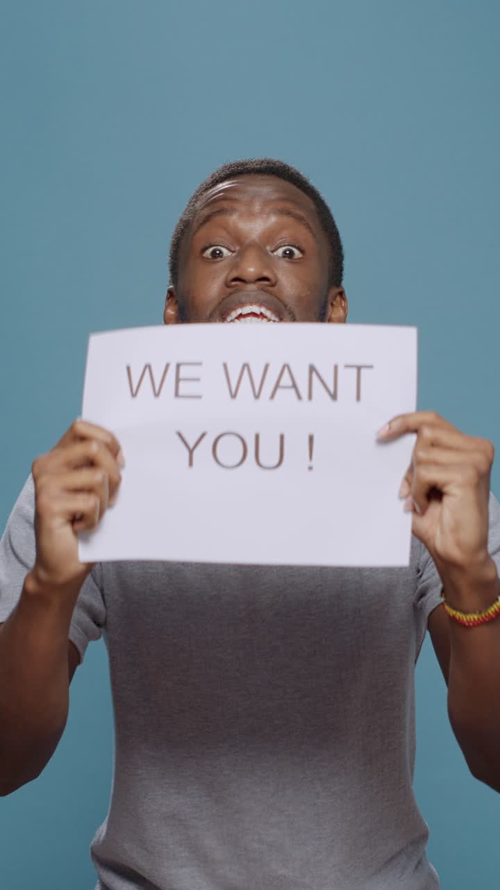 Man Holding We Want You Sign