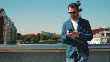 hombre usando el teléfono en un puente de la ciudad