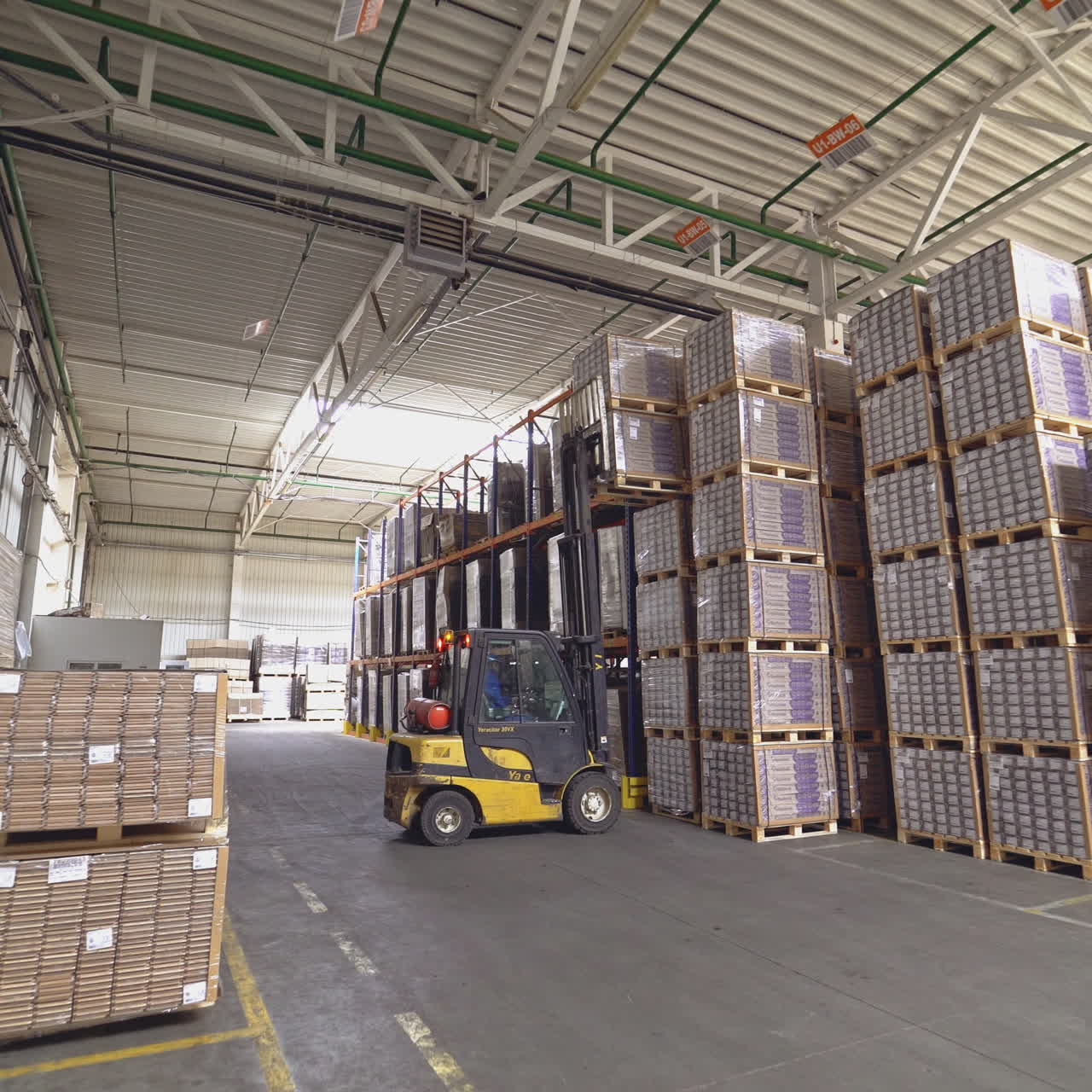 Forklift truck pulled up to a pile of wooden pallets. Large industrial enterprises department