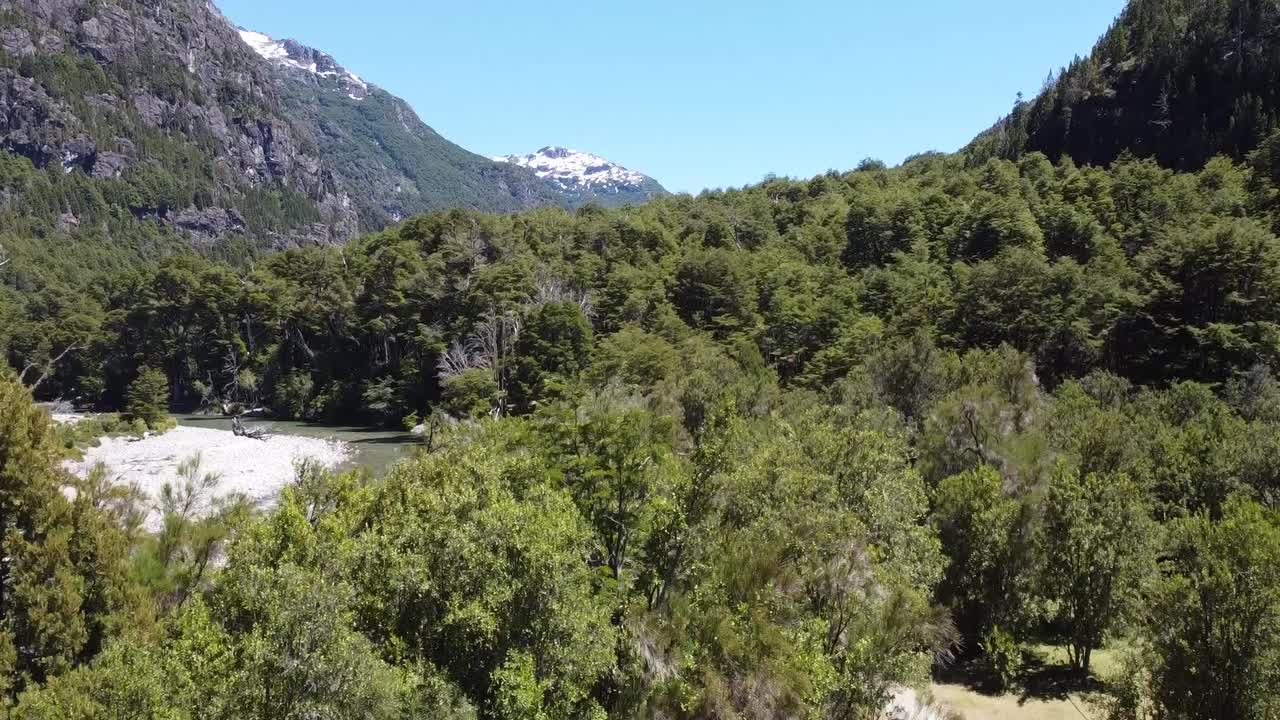 Drone take off shot discovering outstanding blue river and snow mountains in Argentinean Patagonia. shot in summer with DJI mini 3