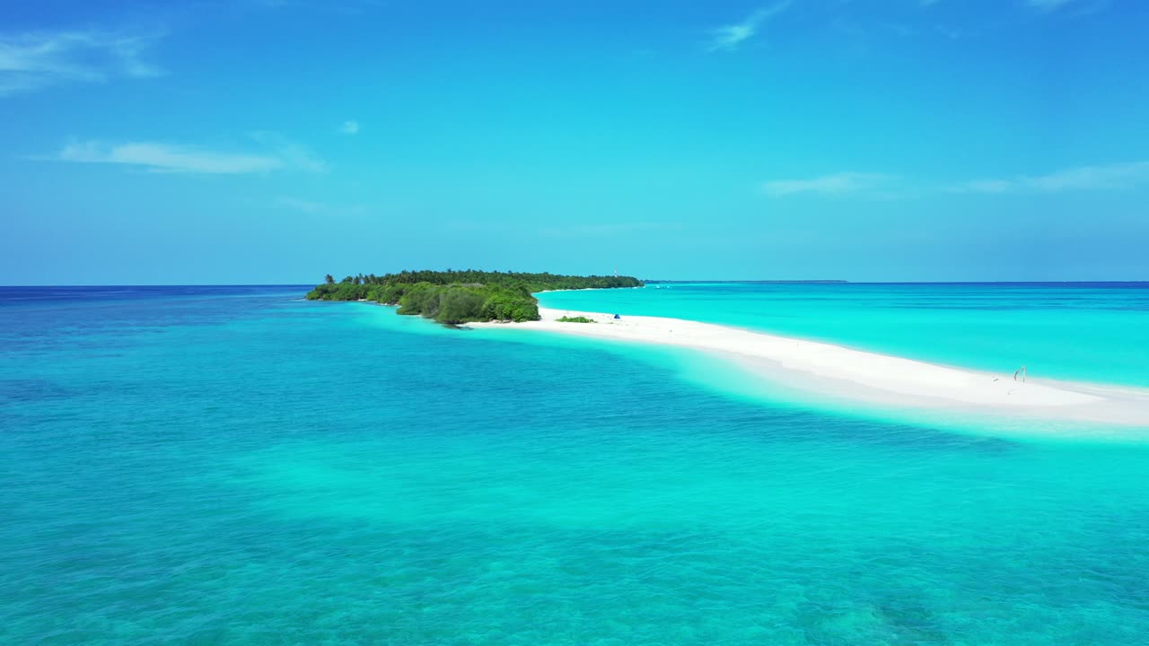 Pristine exotic beach with long sandy stripe extended to wide turquoise lagoon around tropical island on a bright light blue sky in Bora bora